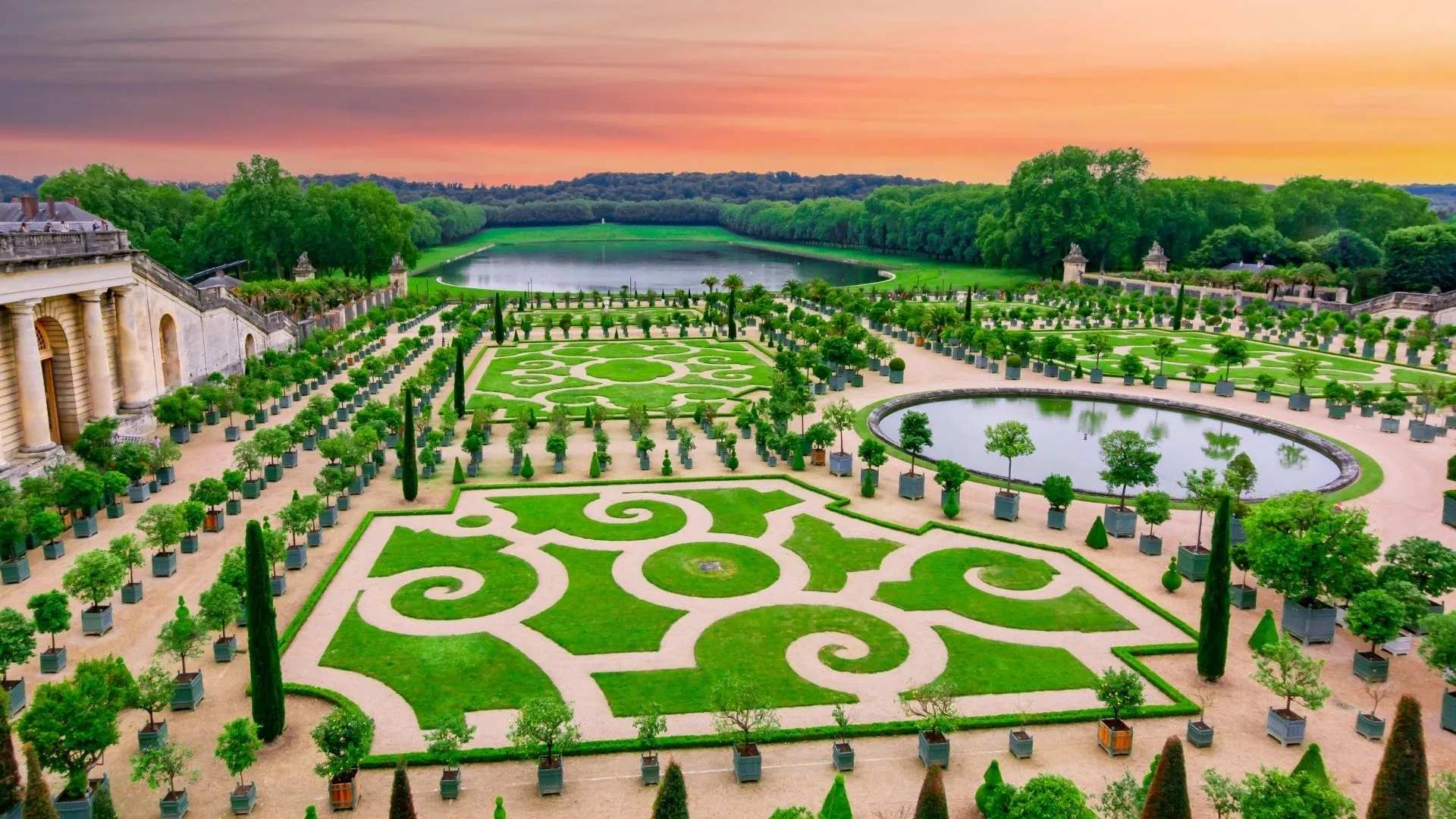 Jardins à la française du château de Versailles au coucher du soleil, Orangerie et parterres dessinés par André Le Nôtre pour Louis XIV au XVIIᵉ siècle